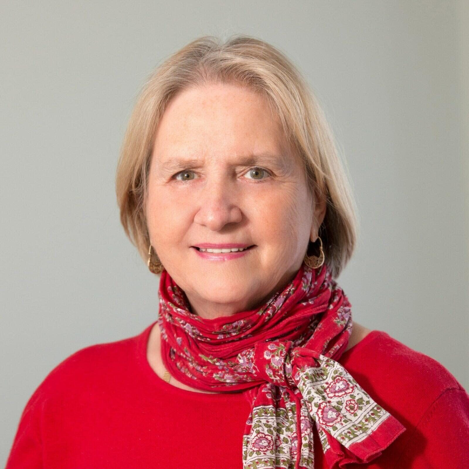 A woman with short blonde hair wearing red apparel